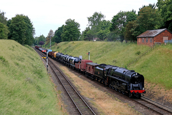 BR Standard Class 9F No 92214 arrives at Rothley on 17.6.23 pulling 9C21 1235 Loughborough to Rothley Station Goods train of 50 wagons for the first time by the railway at GCR 50th Anniversary Celebra