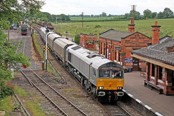 GBRf 66749 in grey livery with 4 biomass hoppers and D7612 at rear passes through Quorn & Woodhouse station,GCR on 3.7.13 to begin 75mph brake and noise testing between Swithland and Little Woodthorpe