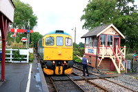 Class 33 No 33202 ' Dennis G Robinson' passes Tenterden Signal Box where the signalman receives the token on 5.8.23 from the driver of the 0950 Northiam to Tenterden service on the Kent and East Susse