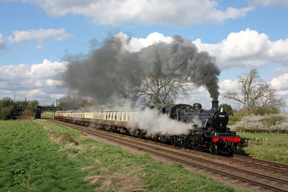 With steam leaking from a boiler valve  and attention needed, BR Standard Class 2MT 2-6-0 No.78018 passes Woodthorpe on 2.4.17 with 1520 Loughborough - Leicester North GCR service
