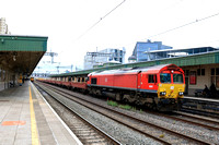 DB Cargo Class 66 No 66097 in red livery rolls through Cardiff Central station on 29.4.24 with 6F07 1054 Margam T.C. to Newport Docks steel train