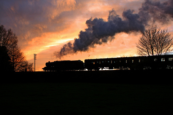 Red 8F No 48624 silhouetted against a magnificent firey sunset at Quorn on 23.11.14 with late running 1530 Loughborough - Leicester North service  at the last Hurrah of the Season 'Steam Gala'