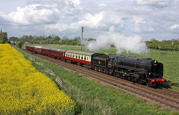 British Railways Standard Class 9F 2-10-0 No.92214 at Woodthorpe alongside a yellow oil rapeseed field on 26.4.14 with 1615 Loughborough - Leicester North GCR service