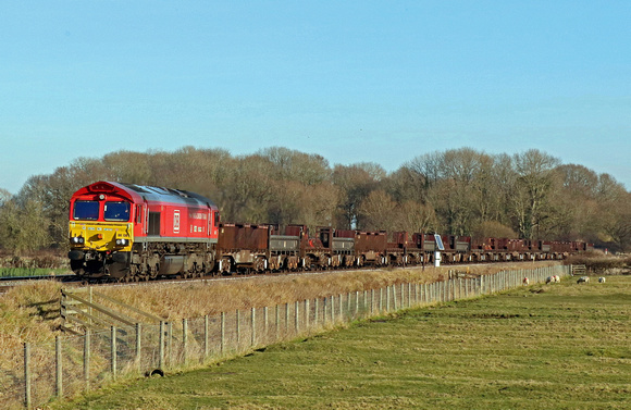DB Cargo 66136 in  red livery with special 'Yiwu- London Train' vinyls passes Rearsby heading towards Syston Junction on 22.1.22 with 6V92 1039 Corby B.S.C. to Margam T.C. empty steel mounts