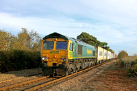 Freightliner Class 66 No 66550 approaches Levington foot crossing on the Felixstowe Branch on 19.10.22 with 4E56 1546 Felixstowe North F.L.T. to Doncaster Ept (F'liners) Intermodal in the low sun
