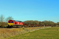 DB Cargo 66136 in red livery with special 'Yiwu- London Train' vinyls passes Rearsby heading towards Syston Junction on 22.1.22 with 6V92 1039 Corby B.S.C. to Margam T.C. empty steel mounts