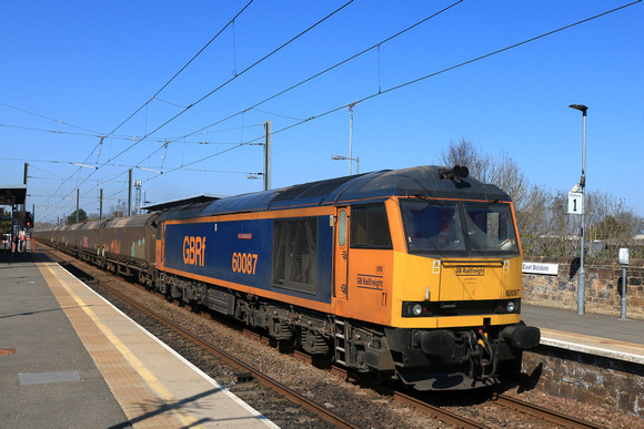 GBRf Class 60 No 60087 Ingleborough passes through Tyne and Wear East Boldon Metro station on 8.4.25 with 6H70 1219 Tyne Coal Terminal Gbrf to Drax Aes (Gbrf) loaded Biomass hoppers