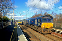 DRS 66421 at Coatbridge Central Station on 22.2.23 with 4D01 1151 Blackford Freight Terminal to Mossend Down Yard Highland Spring Bottled water train. ScotRail 320321 waits with 2C30 1130 Dalmuir to C