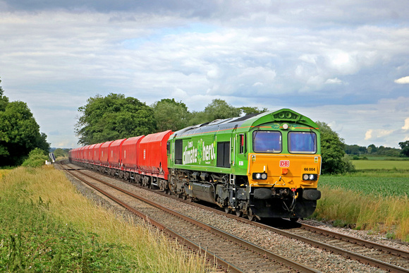 DB Cargo Class 66 green livery 66004 Climate Hero passes East Goscote near Syston East Junction on 24.6.23 with 4M71 1506 Ely Mlf Papworth Sidings to Arpley Sidings loaded red sand hoppers