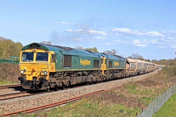 Freightliner Class 66 No's 66540 'Ruby' & 66537 race alongside Hungerford Common on 20.4.23 with a Jumbo 7C77 1220 Wembley Receptions 1-7 to Merehead Quarry (Fhh) empty box hoppers