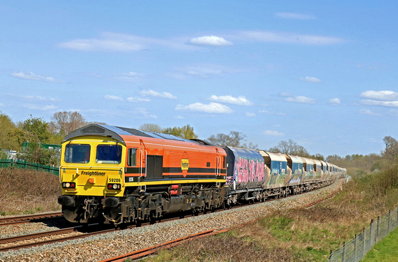 Freightliner Class 59 No 59206 'John F. Yeoman - Rail Pioneer' in G&W livery passes Hungerford Common on 20.4.23 with 6V18 1117 Allington Hanson Agg to Whatley Quarry F Liner HH empty hoppers
