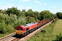 DB Cargo Class 66 No 66143 in red livery at Syston Bypass on 7.7.23 with 6V92 1034 Corby B.S.C. to Margam T.C. mainly empty mixed steel carriers