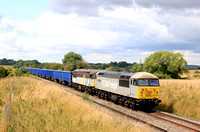 DC Rail Freight Class 56 No's  56091 'Driver Wayne Gaskell' and 56301 in ex Fastline livery at Copley's Brook, Melton Mowbray on 25.7.23 with 4Z43 0947 Chaddesden Sdgs to Willesden Dc Rail Sidings emp