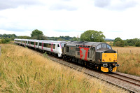 Europhoenix Class 37 No 37510 'Orion' in ROG livery with C2C Class 720 unit No 720601 passes Copley's Brook, Melton Mowbray on 25.7.23 with 5Q72 1004 Derby Litchurch Lane to Wembley Inter City Depot u