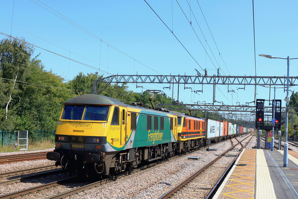 Freightliner Class 90 No's 90049 in Powerhaul livery & 90015 in G & W orange livery race through Colchester Station on 10.8.23 with 4M87 1113 Felixstowe North F.L.T. to Trafford Park F.L.T. Intermodal