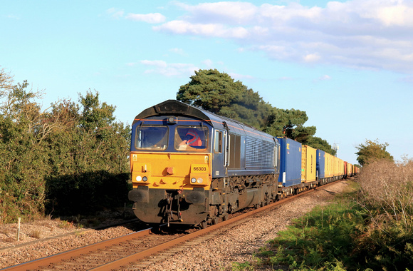 GBRf Class 66 No 66303 formerly DRS and still without any branding approaches Levington Foot Crossing on 22.8.23 with 4M02 1738 Felixstowe North Gbrf to Hams Hall Gbrf Intermodal