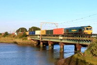 Freightliner Class 66 No 66542 crosses Cattawade Bridge over the River Stour on 21.8.23 with 4S88 1445 Felixstowe North F.L.T. to Coatbridge F.L.T. Intermodal after recessing at Ipswich