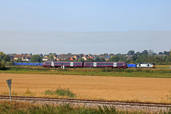 DCR Class 60 No 60046 'William Wilberforce'  waits time at Ely West Junction on 9.9.23 with 6M89 0901 Middleton Towers to Ravenhead Sdgs loaded sand train. EMR 170509 passes with 1R68 0954 Norwich to