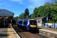 Scotrail Class 170 No 170403 races through the award-winning Aberdour station, Fife on 11.8.24 with 2L57 1132 Edinburgh to Dundee service