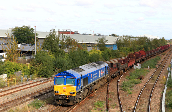 DB Cargo Class 66 No 66023 in 'Kings Coronation' blue livery approaches Leicester Station on 17.10.23 with 6V92 1034 Corby B.S.C. to Margam T.C. empty steel wagons and mounts