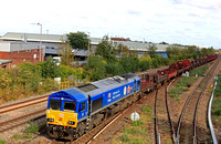 DB Cargo Class 66 No 66023 resplendant in 'Kings Coronation' blue livery approaches Leicester Station on 17.10.23 with 6V92 1034 Corby B.S.C. to Margam T.C. empty steel wagons and mounts