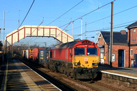 DB Cargo Class 66 No 66078 passes beneath the plaform station bridge at Chester-le-Street . ECML on 6.2.25 with 4E96 0900 Mossend Euroterminal to Tees Dock Bsc Export Berth Intermodal