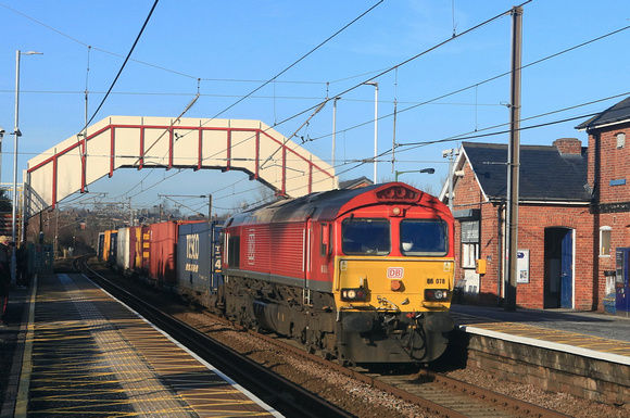 DB Cargo Class 66 No 66078 passes beneath the plaform station bridge at Chester-le-Street . ECML on 6.2.25 with 4E96 0900 Mossend Euroterminal to Tees Dock Bsc Export Berth Intermodal