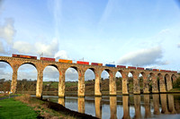 DB Cargo Class 66 No 66087 in EWS livery crosses part of the Royal Border Bridge over the River Tweed at Berwick-upon-Tweed on 21.11.23 with 4E96 0900 Mossend Euroterminal to Tees Dock Bsc Export Bert