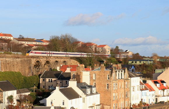 LNER Azuma Class 800 No 800113 crosses Kinghorn Viaduct, Fife above the roof tops of Pettycur Bay, going into Kinghorn station on 21.12.23 with  1E15 0952 Aberdeen to London Kings Cross service