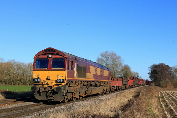 DB Cargo Class 66 No 66063 passes East Goscote near Syston East Junction on 15.1.24 with 6V92 1032 Corby B.S.C. to Margam T.C. empty steel mount carriers