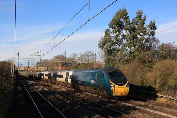 Avanti West Coast  Class 390 Pendolino No 390002 dashes through the shadows at Cathiron near Rugby, WCML on 16.1.24 with 1A35 1155 Manchester Piccadilly to London Euston service
