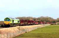 DB Cargo 66004 in special  green “I am a Climate Hero” livery at Rearsby heading towards Syston East Junction on 24.1.24 with 6V92 1032 Corby B.S.C. to Margam T.C. empty steel coil mounts and wagons
