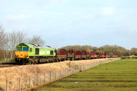 DB Cargo 66004 in special  green “I am a Climate Hero” livery passes Rearsby heading towards Syston East Junction on 24.1.24 with 6V92 1032 Corby B.S.C. to Margam T.C. empty steel coil mounts and wago
