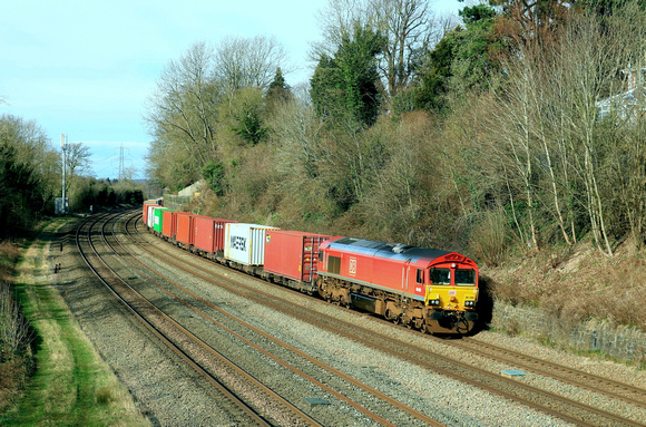 DB Cargo Class 66 No 66086 in red livery passes Barrow upon Soar, MML on 20.2.24 with 4L38 1057 East Mids Gateway Tml Dbc to Felixstowe North Dbc Intermodal