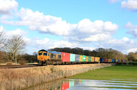 Caught in sunshine and cloud GBRf Class 66 No 66713 'Forest City' passes a flooded field at Rearsby (Leics) on 24.2.24 with 4M23 0935 Felixstowe North Gbrf to Hams Hall Gbrf Intermodal