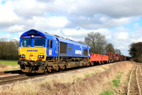 DB Cargo Class 66 No 66148 'Maritime Intermodal Seven' in blue livery passes East Goscote heading towards Syston East Junction on 4.3.24 with 6V92  1034 Corby B.S.C. to Margam T.C. empty steel coil mo