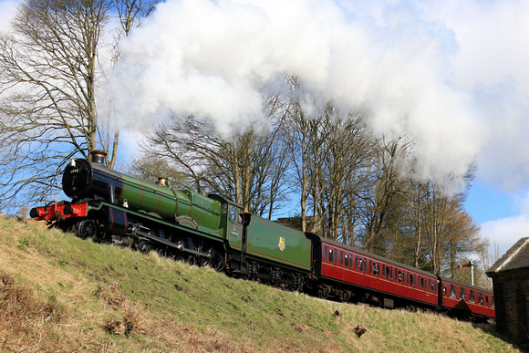 GCR guest loco GWR modified Hall 4-6-0 No.6990 'Witherslack Hall' climbs the steep gradient up past Oakworth Mill on 24.3.24 with 1110 Keighley to Oxenhope at the K&WVR Steam Gala March 2024
