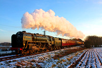 BR Standard Class 7 No 70013 'Oliver Cromwell' catches the low sun turning the steam pink at a snowy Quorn on 28.12.14 with 1500 Leicester North - Loughborough GCR Christmas Holiday Service
