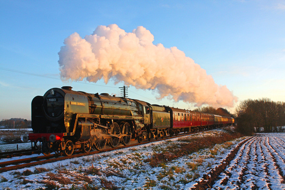 BR Standard Class 7 No 70013 'Oliver Cromwell' catches the low sun turning the steam pink at a snowy Quorn on 28.12.14 with 1500 Leicester North - Loughborough GCR Christmas Holiday Service
