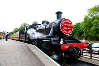 BR Standard Class 2 2-6-0 No 78019 waits at Rothley station on 6.8.24 with 1155 Loughborough to Leicester North midweek service with a holiday express headboard