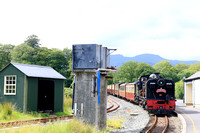 South African NG G16 No.87 passes the water tower, beddgelert station, Ffestiniog and Welsh Highland Railways line on 15.6.24 with 1410 Caernarfon to Porthmadog 'The Harbourmaster ' service