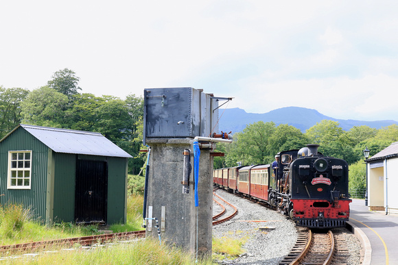 South African NG G16 No.87 passes the water tower, beddgelert station, Ffestiniog and Welsh Highland Railways line on 15.6.24 with 1410 Caernarfon to Porthmadog 'The Harbourmaster ' service