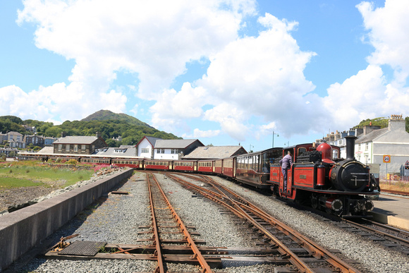 Double Fairlie 'David Lloyd George' waits at Porthmadog station, Ffestiniog and Welsh Highland Railways line on 16.6.24 with empty stock for Boston Lodge Workshops at the end of the Cob, Porthmadog